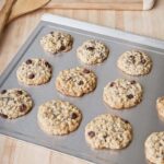 Large steel cooking sheet with oatmeal raisin cookies.