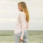 Backview of woman at the beach wearing blush longsleeve t-shirt