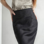 Woman wearing tight, black linen pencil skirt with light-grey tank top.