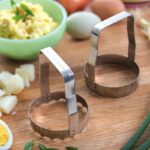 Food choppers with plain and serrated blades standing on table with chopped foods.