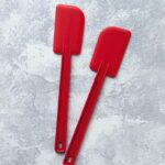 Pair of red nylon scraping spatulas.