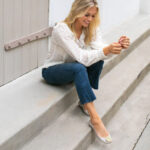 Woman sitting on steps wearing Oka-B ballet flats