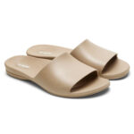 Beige women's flip flops with broad, overarching straps