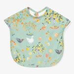 Green bib decorated with beautiful drawings of chickens, fruit and fruit trees.