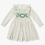 White longsleeve kids' dress with grey square lines pattern and frills and embroidery around the waist, neckline and sleeves.