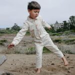 Kid wearing jumpsuit while playing in the sand