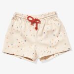 Light-pink kids' shorts decorated with small dots in various colors and a red drawstring.