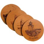 Light leather coasters engraved with a drawing of a lighthouse and the word "Maine"