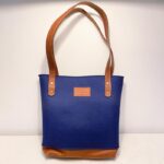 Blue felt bag with leather detailing and carrying straps