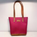 Pink felt bag with leather detailing and straps