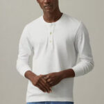 Man wearing white, longsleeve t-shirt with button-down neckline.