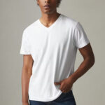 Man wearing white, shortdleeve t-shirt with v-neck.