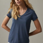 Woman wearing navy, short sleeve, v-neck t-shirt.