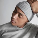 Young man wearing light grey beanie hat.