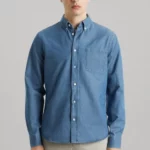 Man wearing blue denim shirt with front pocket.