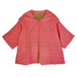 Coral colored tweed car coat with short sleeves and broad collar.