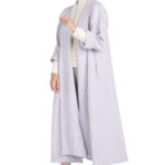 Woman wearing swing coat with ivory and lavender pattern.