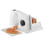 Medium sized electric food slicer slicing blood oranges.