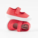 Pink kids' shoes with velcro straps and white soles.