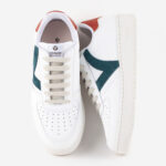 White women's sneakers with red and dark green detailing.