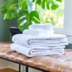 White cotton towels lying on bench.