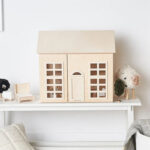 Natural, unpainted wooden dollhouse.