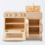 Natural wooden play kitchen with oven, stove and sink.